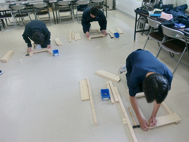 鋸や金槌で木製椅子の骨組み作り
