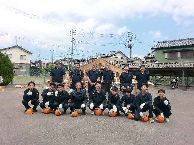 完成した木造屋根の前で記念撮影